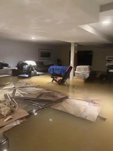 Finished basement with standing floodwater and floating debris